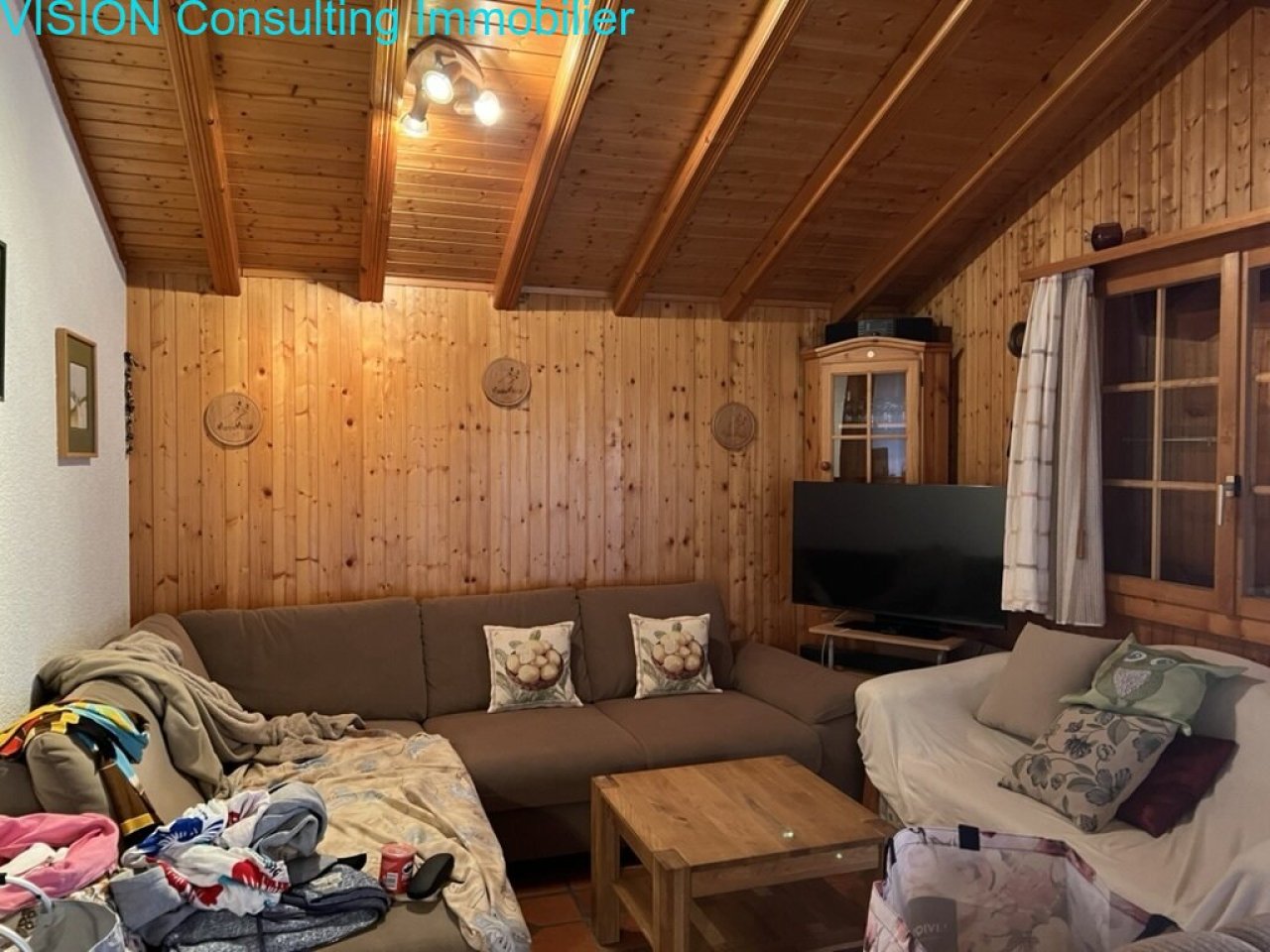 Salon avec plafond à poutres en bois et accès direct à la terrasse