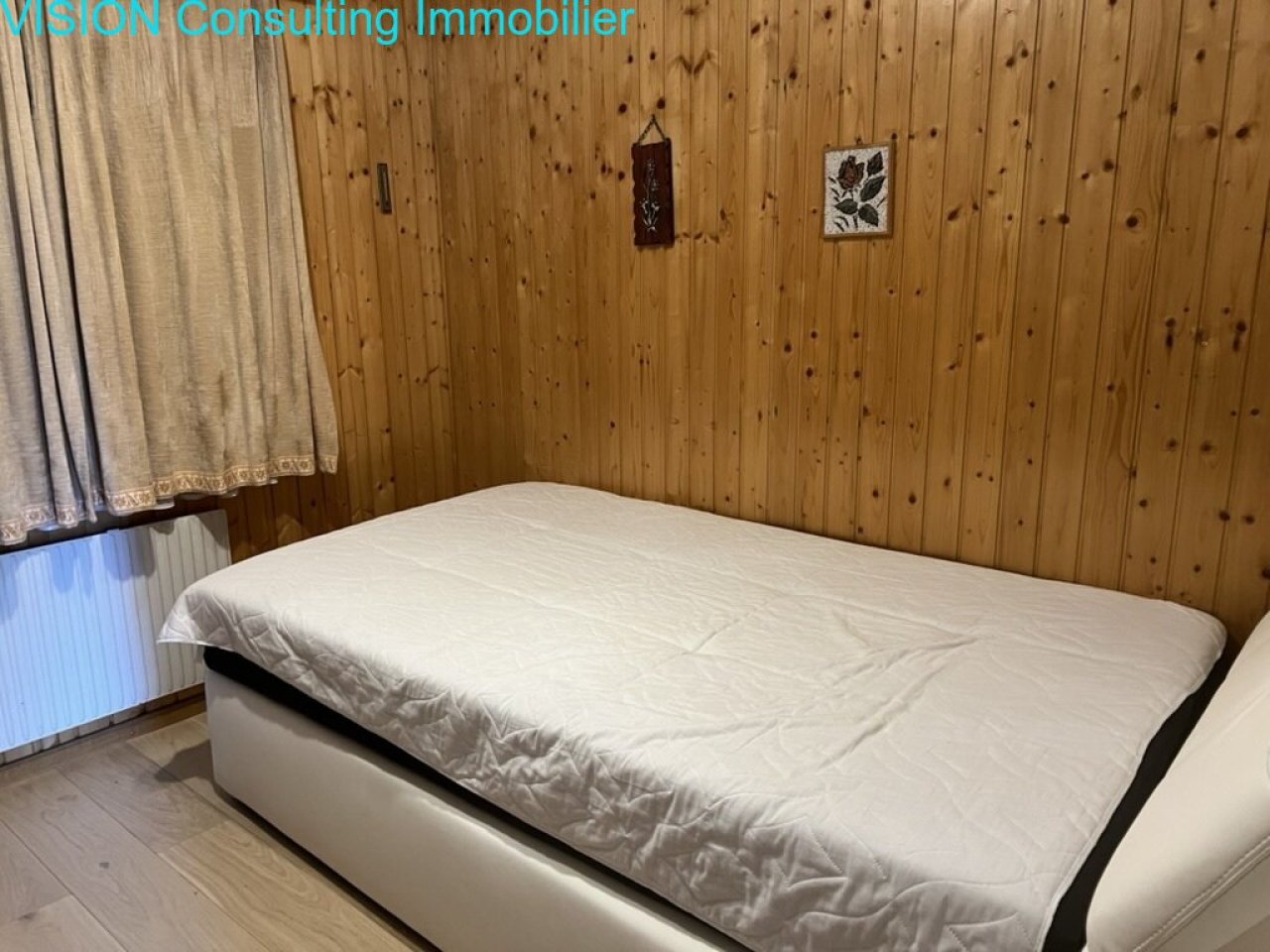 Chambre à coucher avec un revêtement en bois thermiquement isolant et un radiateur