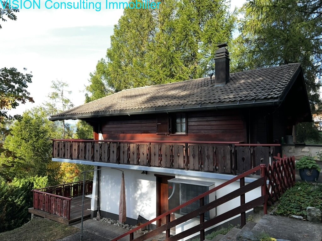Maison en bois traditionnelle avec une véranda accueillante et une vue pittoresque sur la nature